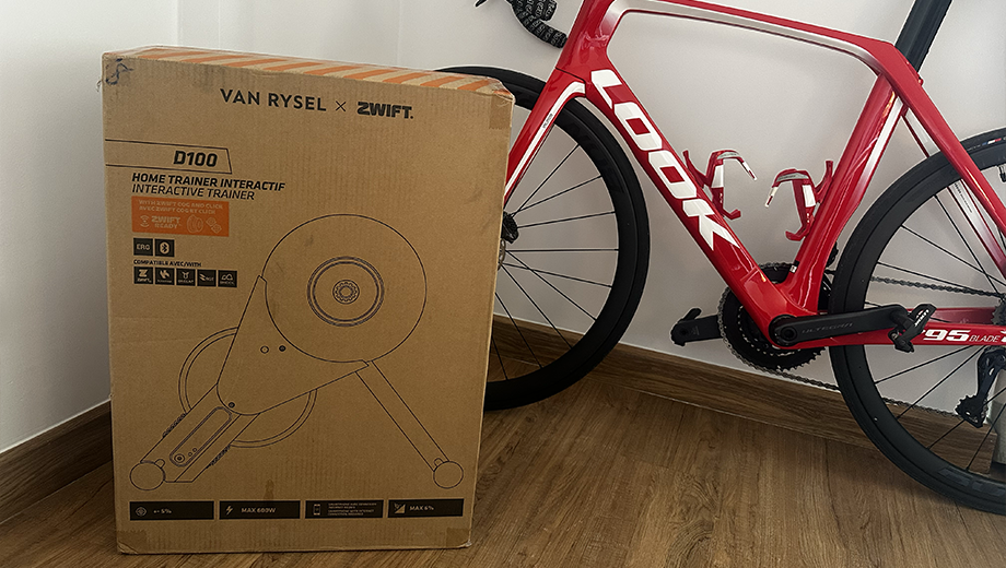 Carton du Van Rysel D100 avec Zwift Cog & Click posé à coté du vélo